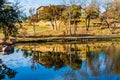 Ranch House and Fall Color Reflecting In Water of Calm Lake on Hill Country Ranch Royalty Free Stock Photo