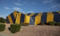 Yellow and blue striped termite tent covering a ranch style house Royalty Free Stock Photo