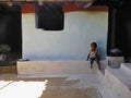 RANCHHA VILLAGE, MADHYA PRADESH, INDIA, March 2012, Small kid sits outside his house during afternoon Royalty Free Stock Photo