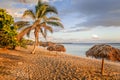 Rancho Luna sandy beach with palms and straw umbrellas on the shore, Cienfuegos, Cuba