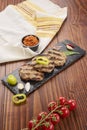 Grilled Veal minced meat with spices on black stone and wooden background Royalty Free Stock Photo