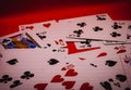 A random pile of playing cards against a red backdrop