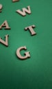 Random wooden letters isolated on green