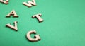 Random wooden letters isolated on green