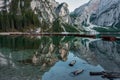 Range of boats in the Braies Lake with the reflection of high rocky mountains in Italy Royalty Free Stock Photo