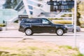 Range Rover L405 side view. Sport SUV black color driving against a background of modern buildings. Full size luxury crossover in