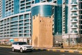 Range Rover Moving In Street Of City Of Ajman. Ancient Old Stone AlMurabbaa Watchtower Of Ajman. Famous Landmark