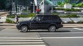 Range Rover Vogue suv car is driving on high speed on the street. Premium black british crossover third generation L322 in motion