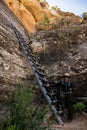 Ranger Leans Against Wooden Ladder While Giving the History of the Square House Tower at Mesa Verde