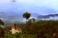 Beautiful landscape with forest and pines, mountain cottage and fog and low clouds in the mountains.