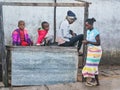 Ranohira, Madagascar - April 29, 2019: Four unknown Malagasy children playing next to unused wooden market stall, smallest sitting