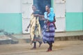 Ranohira, Madagascar - April 29, 2019: Two unknown Malagasy women walking on main street, one carrying her baby. People of