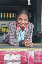 Ranohira, Madagascar - April 29, 2019: Unknown Malagasy woman shopkeeper leaning at table, smiling, in her market stall on the