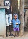 Ranohira, Madagascar - April 29, 2019: Unknown small Malagasy boy kid in blue denim jacked and shorts standing next to his father