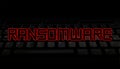Ransomware red text over black keyboard illustration