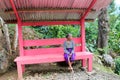 Elderly indonesian woman sitting on a pink bench Royalty Free Stock Photo