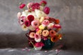 Ranunculus asiaticus or Persian buttercup bouquet in antique jug. Floral composition on grey backgound