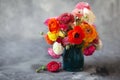 Ranunculus asiaticus or Persian buttercup bouquet in antique jug. Floral composition on grey backgound