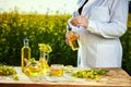 Rapeseed oil bottle in hand of an agronomist or biologist on background rape field Royalty Free Stock Photo