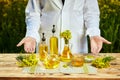 Rapeseed oil bottle in hand of an agronomist or biologist on background rape field