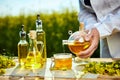 Rapeseed oil bottle in hand of an agronomist or biologist on background rape field Royalty Free Stock Photo