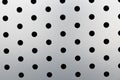 Rapid black dot pattern on gray background, round holes texture on perforated metal panel surface. Royalty Free Stock Photo