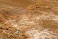 Rapid flow of brown water in the muddy river during rainy season