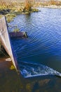 The rapid flow of water is directed to the pipe with the discharge of water below the level. Auxiliary structure on the dam Royalty Free Stock Photo