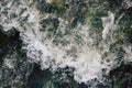 The rapid flow of water with white waves and air bubbles. Top view of a stream of fast flowing water