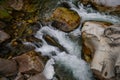 Rapid and powerful water flow between large rocks, close-up. Boulders in cold mountain river. Natural backgrounds Royalty Free Stock Photo