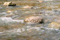 Rapid and powerful water flow between large rocks, close-up. Boulders in cold mountain river. Natural backgrounds Royalty Free Stock Photo