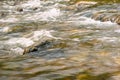 Rapid and powerful water flow between large rocks, close-up. Boulders in cold mountain river. Natural backgrounds Royalty Free Stock Photo