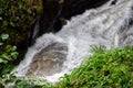 Rapid and powerful water flow between large rocks in cold mountain river, closeup