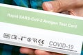 Rapid SARS-Cov-2 Antigen Test Card COVID-19 coronavirus test package, box held in hand, detail, extreme closeup, man holding an