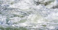 Rapid spring river flowing over rocks on sunny day, forming white water waves, closeup detail - abstract nature Royalty Free Stock Photo