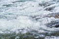 Rapid spring river flowing over rocks on sunny day, forming white water waves, closeup detail - abstract nature background Royalty Free Stock Photo