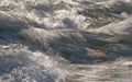 Rapid spring river flowing over rocks on sunny day, forming white water waves, longer exposure looks like threads, closeup detail Royalty Free Stock Photo