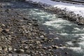 A rapids of mountain rivers with fast water and large rocky boulders. Rapid flow of a mountain river in spring, close-up Royalty Free Stock Photo
