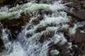 Rapids of mountain rivers with fast water and large rocky boulders. Rapid flow of a mountain river in spring, close-up Royalty Free Stock Photo