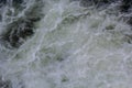 Rapids of mountain rivers with fast water and large rocky boulders. Rapid flow of a mountain river in spring, close-up Royalty Free Stock Photo