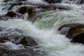 rapids of mountain rivers with fast water and large rocky boulders. Rapid flow of a mountain river in spring, close-up Royalty Free Stock Photo