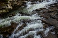 rapids of mountain rivers with fast water and large rocky boulders. Rapid flow of a mountain river in spring, close-up Royalty Free Stock Photo