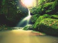 Rapids on small mountain stream between mossy basalt rocks. Blurred water running over stones Royalty Free Stock Photo