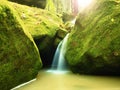 Rapids on small mountain stream between mossy basalt rocks. Blurred water running over stones Royalty Free Stock Photo