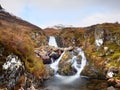 Rapids in small waterfall on stream, Higland in Scotland an early spring day. Snowy mountain peaks