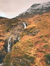 Rapids in small waterfall on stream, Higland in Scotland an early spring day. Snowy mountain peaks