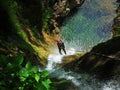 Rappelling on forest waterfall