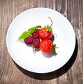 Rapsberry and strawberry on whitte plate Royalty Free Stock Photo