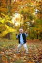Rapturous and happy child boy stands in autumn forest Royalty Free Stock Photo