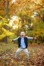 Rapturous and happy child boy stands in autumn forest Royalty Free Stock Photo